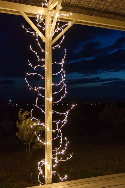 Branche lumineuse led entourant le pilier d'un abris de jardin