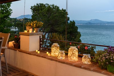 Muret de terrasse d&eacute;cor&eacute; avec des pots en verre remplis de microled et petites bougies