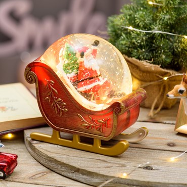 Slitta decorata con Babbo Natale a batteria, rosso antico con glitter scintillante nell'acqua, h 17,5 cm, led bianco caldo