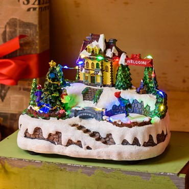 Batteriebetriebenes Weihnachtsdorf aus Polyresin, mit Schlittschuhläufern, Weihnachtsbäumen und rotierenden Kindern, h 15 cm, mit Weihnachtsliedern